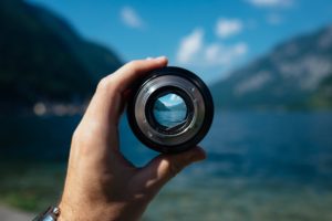 Picture of a person looking out of a valley through a monocular