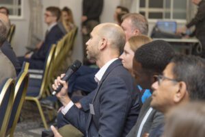 Audience at an event with a participant holding a microphone.